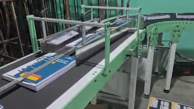Conveyor guiding books toward the next section